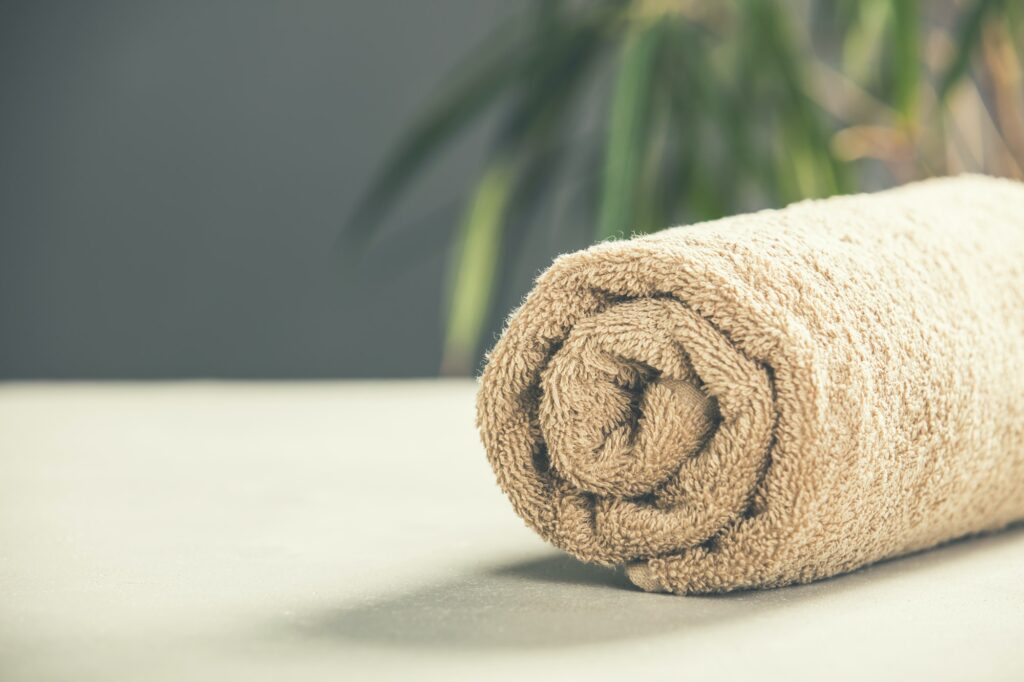 Brown Towel on concrete background - SPA and relaxation concept